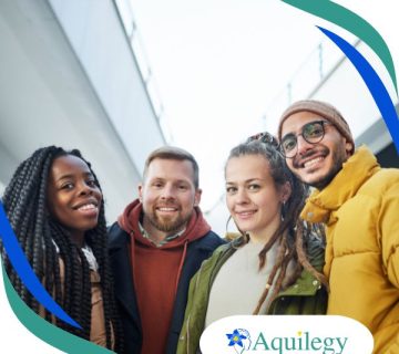 Four people smiling at the camera outdoors near a modern building, with "Aquilegy" logo in the bottom right corner.