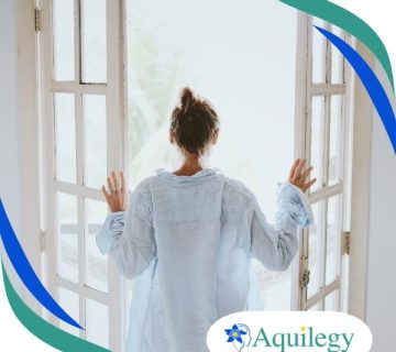 A person in a light shirt stands with their back to the camera, opening glass doors to a bright outdoor area. Aquilegy logo is displayed in the bottom right corner.